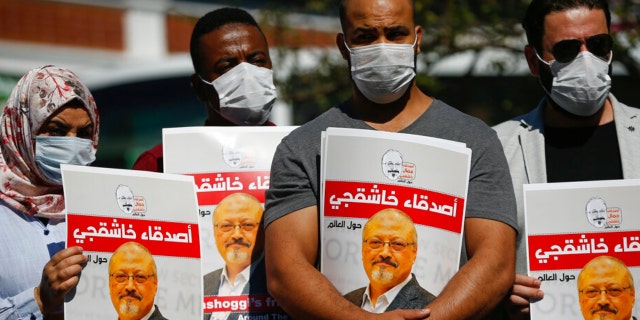 People hold posters of slain Saudi journalist Jamal Khashoggi, near the Saudi Arabia consulate in Istanbul, marking the two-year anniversary of his death, Oct. 2, 2020. A Turkish court ruled Thursday, April 7, 2022, to suspend the trial in absentia of 26 Saudis accused in the gruesome killing of Washington Post columnist Jamal Khashoggi and for the case to be transferred to Saudi Arabia.