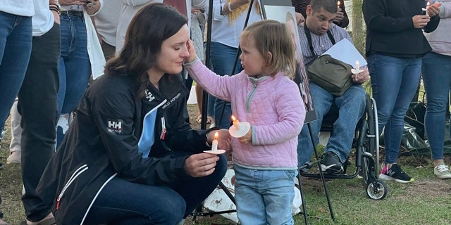 Kirsten Bridegan and her daughter Bexley at a vigil April 19 for her slain husband.