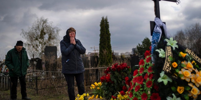 Galyna Bondar, weeps beside the grave of her son Oleksandr, 32, after burying him in the Bucha cemetery on the outskirts of Kiev, Ukraine on Saturday April 16, 2022. Oleksandr, who joined the Ukrainian territorial defense as a co-l 'computer officer was killed by a gunshot from the Russian army. 
