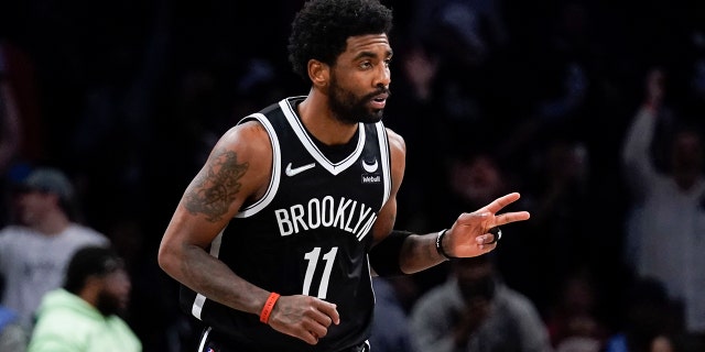 The Brooklyn Nets' Kyrie Irving reacts after hitting a basket against the Cleveland Cavaliers during the first half of the opening game of the NBA play-in tournament April 12, 2022, in New York.