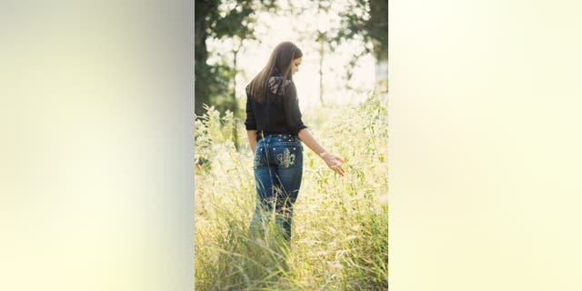 Lydia walking through a field.