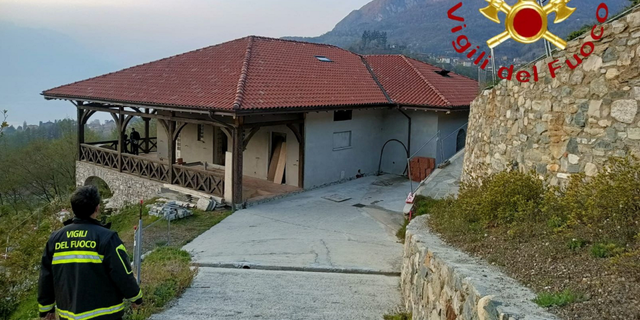 A firefighter walks by the villa owned by Russian TV presenter Vladimir Solovyev, after unidentified people attempted to set fire to it, in Menaggio, on Lake Como, Italy, on Wednesday.