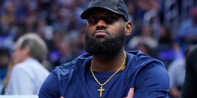 The Los Angeles Lakers' LeBron James sits on the bench during the first half of the team's NBA game against the Golden State Warriors in San Francisco on April 7, 2022.