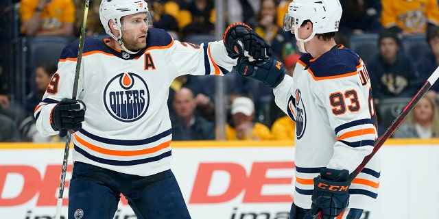 Edmonton Oilers' Leon Draisaitl (29) is congratulated by Ryan Nugent-Hopkins (93) after Draisaitl scored a goal against the Nashville Predators in the first period of an NHL hockey game Thursday, April 14, 2022, in Nashville, Tenn.
