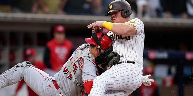 Cincinnati Reds catcher Tyler Stephenson, left, tags out the San Diego Padres' Luke Voit, who was trying to score from first off a double by Jurickson Profar during the first inning of a game Tuesday, April 19, 2022, in San Diego.