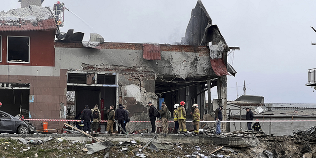Emergency workers clear up debris after an airstrike hit a tire shop in the western city of Lviv, Ukraine, on Monday, April 25, 2022. 