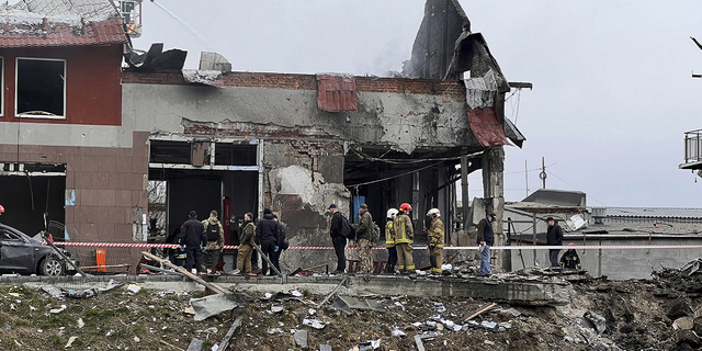 Emergency workers clear up debris after an airstrike hit a tire shop in the western city of Lviv, Ukraine, on Monday.