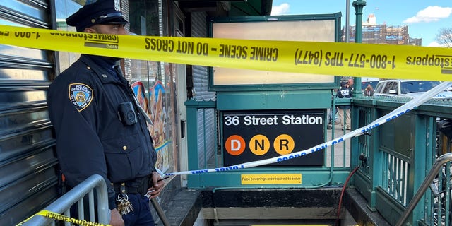 El oficial de la MTA se para afuera del metro cerrado