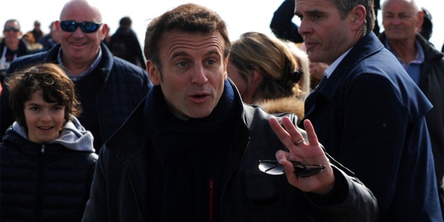 French President and centrist presidential candidate for re-election Emmanuel Macron gestures as he walks after casting his vote in the first round of the presidential election, Sunday April 10, 2022 in Le Touquet, northern France.