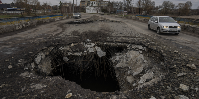 Cars drive near a damaged bridge following a Russian attack in the previous weeks in the town of Makarov in the Kyiv region on Sunday.