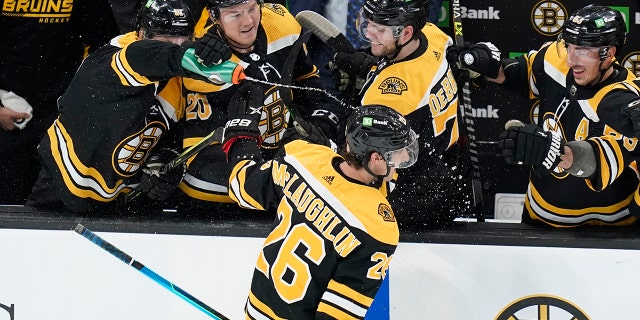 Boston Bruins center Marc McLaughlin (26) is sprayed with water and congratulated by teammates after scoring his first NHL goal, against New Jersey Devils goaltender Jon Gillies during the second period of a hockey game Thursday, Maart 31, 2022, in Boston.