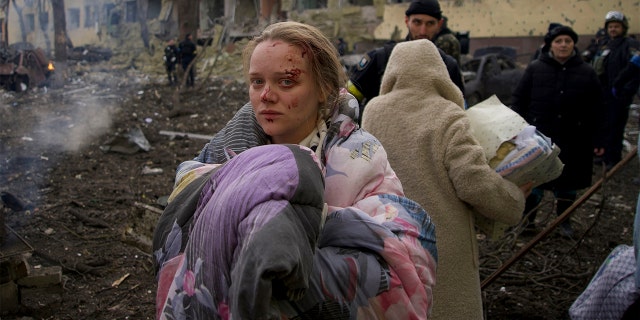 FILE - Marianna Vishegirskaya stands outside a maternity hospital that was damaged by shelling in Mariupol, Ukraine, Wednesday, March 9, 2022.