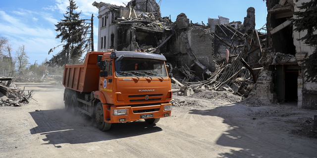A truck drives past the theater damaged during fighting in Mariupol, in eastern Ukraine, on Wednesday, April 27.