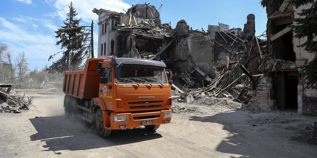 A truck drives past the theater damaged during fighting in Mariupol, in eastern Ukraine, on Wednesday, April 27.