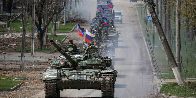 Een konvooi van pro-Russische troepen trekt op donderdag 21 april langs een weg in Mariupol, Oekraïne.