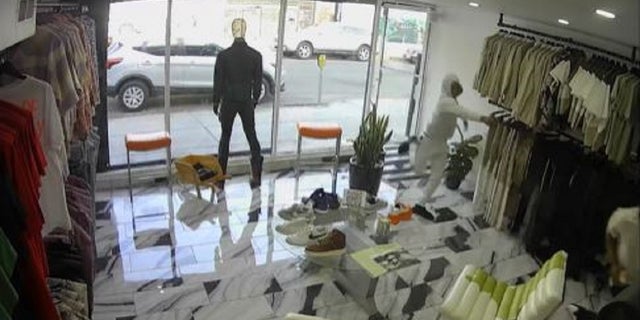 A pair of suspects were caught on security footage opening fire in a Los Angeles clothing store during attempted robbery, police said.