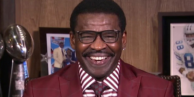 En esta imagen fija de un video proporcionado por la NFL, el ex receptor abierto de los Dallas Cowboys, Michael Irvin, sonríe durante la primera ronda del Draft de la NFL 2020 el 23 de abril de 2020.