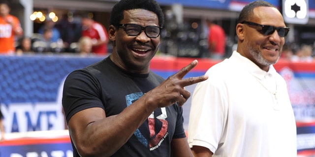 El ex receptor abierto de los Miami Hurricanes, Michael Irvin, reacciona ante los fanáticos de los Hurricanes al margen antes de su partido contra Alabama Crimson Tide en el Mercedes-Benz Stadium.