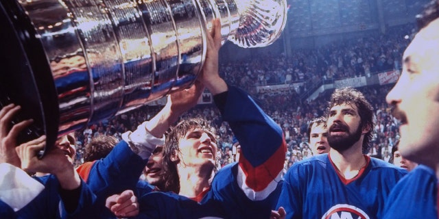 Hockey: NHL Finals: New York Islanders Mike Bossy (22) victorious holding up Stanley Cup with teammates after winning game and series vs Vancouver Canucks at Pacific Coliseum. Game 4. Vancouver, Canada 5/16/1982