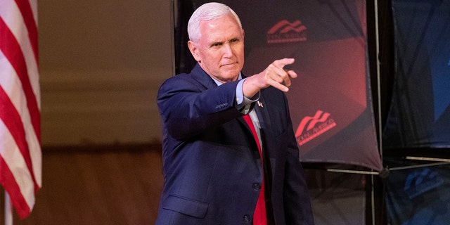 Former Vice President Mike Pence points as he arrives to speak at a campus lecture hosted by Young Americans for Freedom at the University of Virginia in Charlottesville, Va., April 12, 2022. 