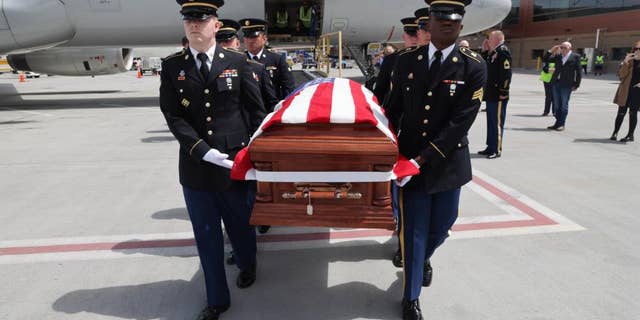 Honor Guard made up of members of the Utah National Guard conduct an Honorable Carry of Army Cpl. David B. Milano's remains at the Salt Lake City International Airport, April 26, 2022.