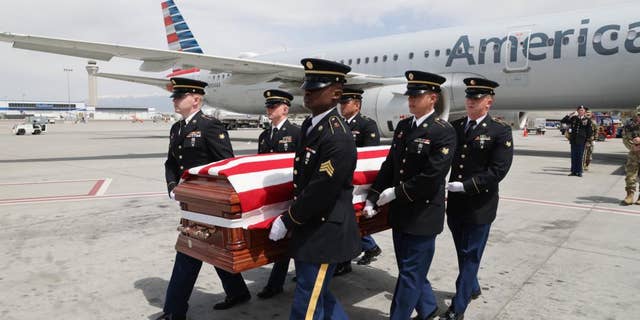 Honor Guard made up of members of the Utah National Guard conduct an Honorable Carry of Army Cpl. David B. Milano's remains at the Salt Lake City International Airport, April 26, 2022.