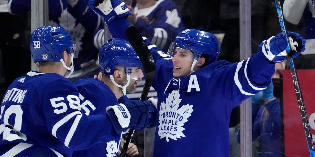Toronto Maple Leafs right wing Mitchell Marner (16) celebrates his goal with teammates Michael Bunting (58) and Mark Giordano (55) during first period NHL hockey game in Toronto, Sunday, April 17, 2022.