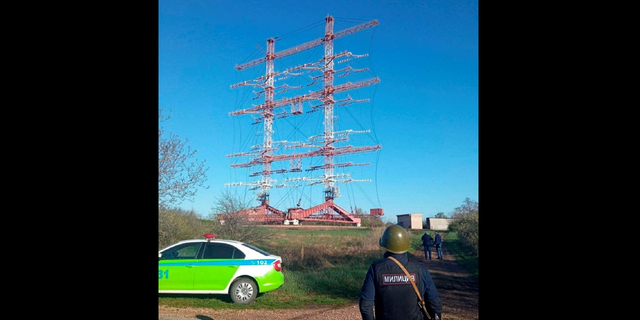 Authorities stand guard in front of radio antennas in Maiac following the blasts Tuesday. 