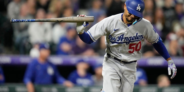 Los Angeles Dodgers' Mookie Betts tosses his bat after connecting for an RBI-single off Colorado Rockies relief pitcher Alex Colome in the eighth inning of a baseball game Saturday, April 9, 2022, in Denver.