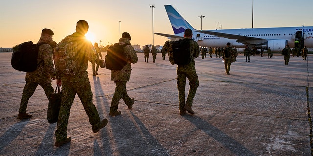 أفراد عسكريون برتغاليون عند شروق الشمس لنشرهم في رومانيا من مطار فيغو مادورو العسكري في 15 أبريل 2022 في لشبونة ، البرتغال. 