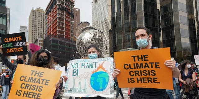 People carry signs at the March for Science in collaboration with Extinction Rebellion NYC and other organizations on April 23, 2022 in New York, one day after Earth Day. 