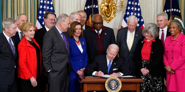 President Biden signs the Postal Service Reform Act of 2022 in the State Dining Room at the White House in Washington on April 6, 2022.