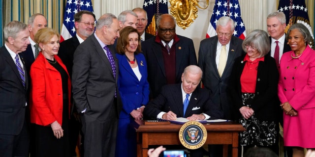 President Biden signs the Postal Service Reform Act of 2022 in the State Dining Room at the White House in Washington on April 6, 2022.