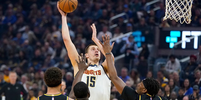 Denver Nuggets center Nikola Jokic (15) shoots against the Golden State Warriors during the first half of Game 1 of an NBA basketball first-round playoff series in San Francisco, 土曜日, 4月 16, 2022.