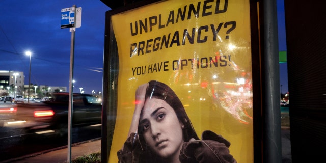 FILE PHOTO: A billboard advertising adoption services targets pregnant women at a bus stop in Oklahoma City, Oklahoma, U.S., December 7, 2021. 