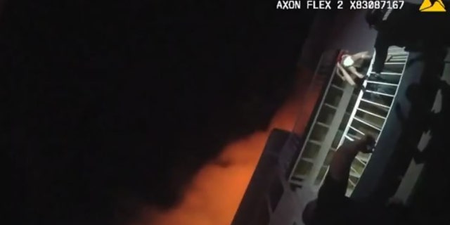 Orange County Sheriff’s Deputy William Puzynski hands down a 2-year-old child to deputies on the ground during an apartment fire rescue on Saturday morning.