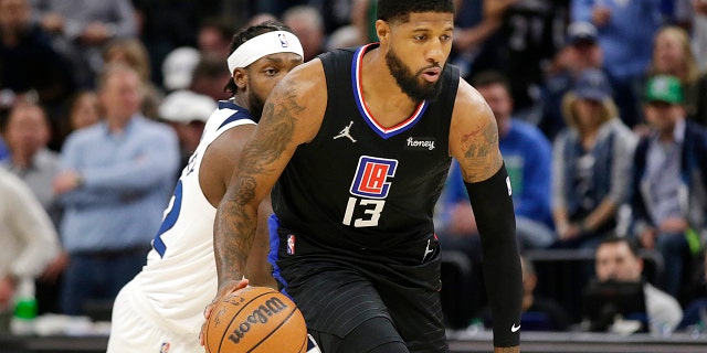 Los Angeles Clippers guard Paul George (13) drives past Minnesota Timberwolves guard Patrick Beverley (22) during the first quarter of a game Tuesday, April 12, 2022, in Minneapolis.