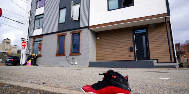 A lone sneaker lies near a short-term rental property where police say a shooting took place in Pittsburgh early Sunday morning, April 17, 2022.