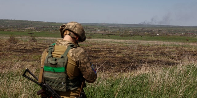 A Ukrainian serviceman looks as smoke rises after a Russian troops shelling, as Russia's attack on Ukraine continues, in Luhansk Region, Ukraine April 26, 2022.