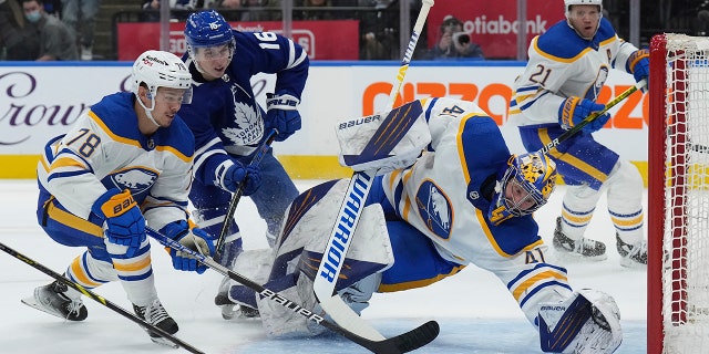 Buffalo Sabres goaltender Craig Anderson (41) makes a diving save as Toronto Maple Leafs forward Mitchell Marner (16) and Sabres defenseman Jacob Bryson (78) look for a possible rebound during the second period of an NHL hockey game Tuesday, April 12, 2022, in Toronto.