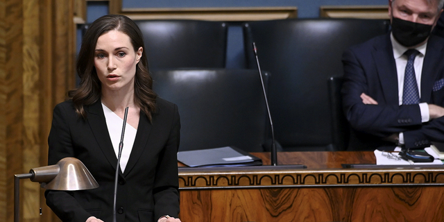 Finnish Prime Minister Sanna Marin speaks while Foreign Minister Pekka Haavisto looks on, during a plenary session at the Finnish Parliament in Helsinki, Finland, on Wednesday.