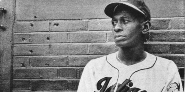 Satchel Paige rests in the Cleveland Indians' bullpen during a game at Metropolitan Stadium in Cleveland in 1948.