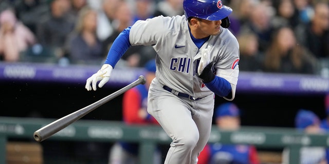 Chicago Cubs' Seiya Suzuki heads to first base as Colorado Rockies shortstop Jose Iglesias mishandles the ball for an error in the third inning of a baseball game Thursday, April 14, 2022, in Denver.