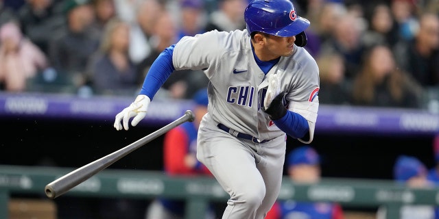 Chicago Cubs' Seiya Suzuki heads to first base as Colorado Rockies shortstop Jose Iglesias mishandles the ball for an error in the third inning of a baseball game Thursday, April 14, 2022, in Denver.
