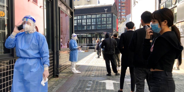 Residents line up for mass testing in a lockdown area in Jingan district in Puxi area of western Shanghai, Monday, April 4, 2022.