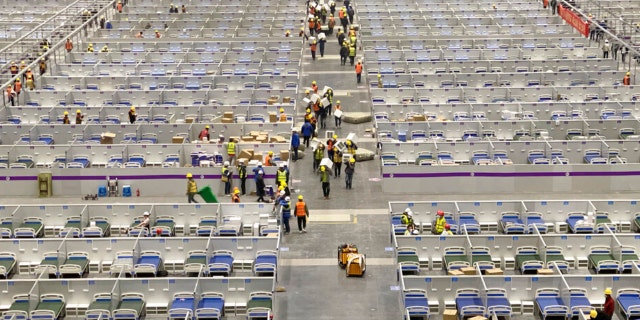 In this photo released by Xinhua News Agency, workers labor at the site of a temporary hospital being constructed at the National Exhibition and Convention Center (Shanghai) in east China's Shanghai, April 8, 2022. China's largest city of Shanghai will soon begin lifting lockdown in communities that report no positive cases within 14 days after another round of COVID-19 testing, authorities said Saturday.