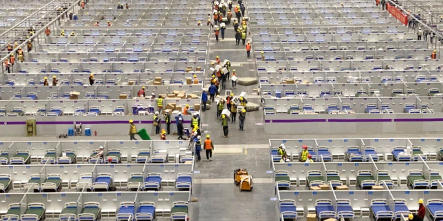 In this photo released by Xinhua News Agency, workers labor at the site of a temporary hospital being constructed at the National Exhibition and Convention Center (Shanghai) in east China's Shanghai, April 8, 2022. China's largest city of Shanghai will soon begin lifting lockdown in communities that report no positive cases within 14 days after another round of COVID-19 testing, authorities said Saturday.  