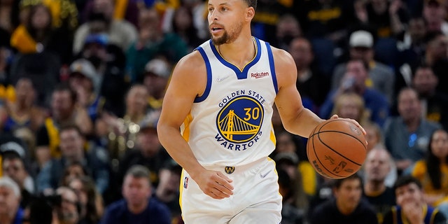 Golden State Warriors guard Stephen Curry dribbles the ball up the court against the Denver Nuggets during the second half of Game 2 of an NBA basketball first-round playoff series in San Francisco, Monday, April 18, 2022.