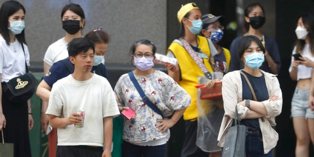 People wear face masks to help protect against the spread of the coronavirus in Taipei, Taiwan, Thursday, April 28, 2022. Taiwan, which had been living mostly free of COVID-19, is now facing its worst outbreak since the beginning of the pandemic with over 11,000 new cases reported Thursday. 