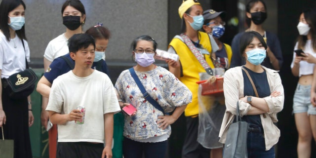 People wear face masks to help protect against the spread of the coronavirus in Taipei, Taiwan, Thursday, April 28, 2022. Taiwan, which had been living mostly free of COVID-19, is now facing its worst outbreak since the beginning of the pandemic with over 11,000 new cases reported Thursday. 